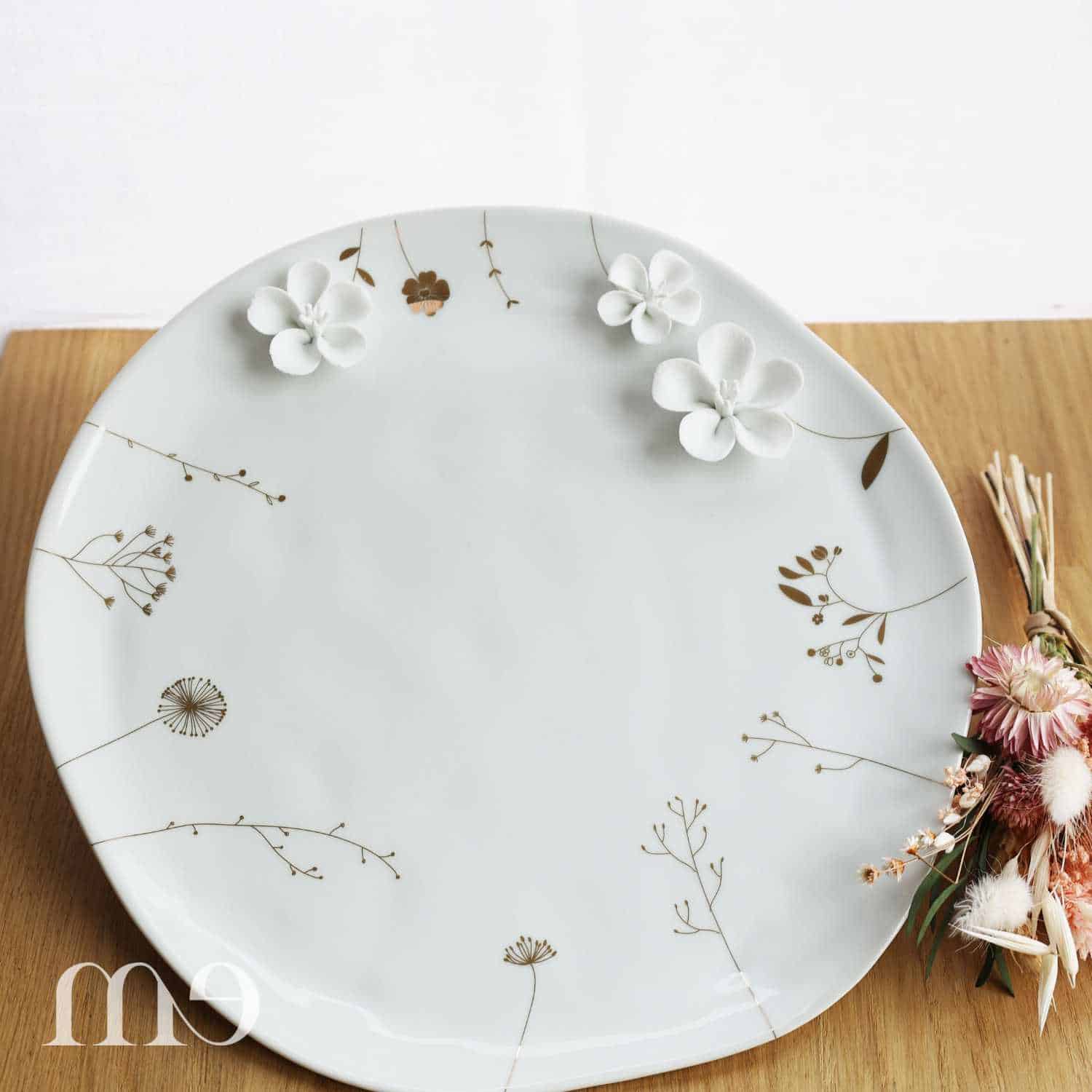 Assiette en porcelaine de la marque Räder avec des fleurs en relief et de la dorure fleurie